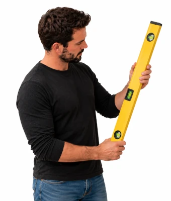 Man holding a level to assist in installing acoustic slat wall panels
