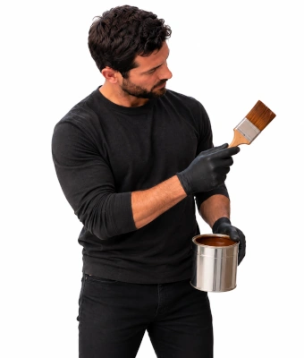 Man holding a woodstain paintbrush for installing a Trellis Privacy screen for patio