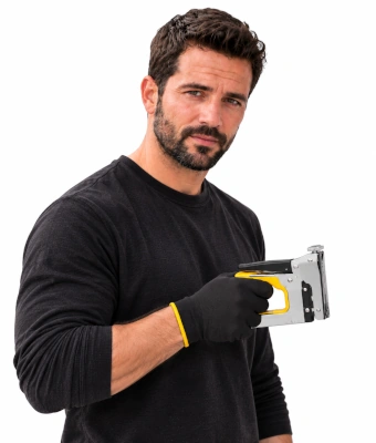 Man holding a heavy-duty staple gun to help insulate underneath suspended timber floors